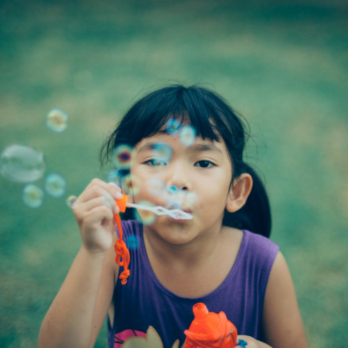 Enfant soufflant des bulles de savon